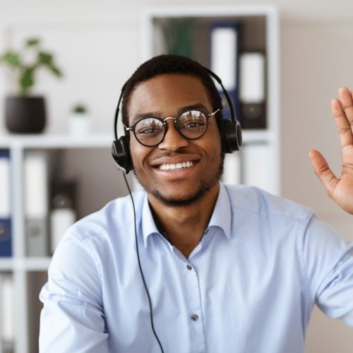 happy-black-consultant-with-headset-waving-at-camera.jpg